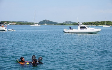 Underwater cleanup in progress with Police Department guarding the area